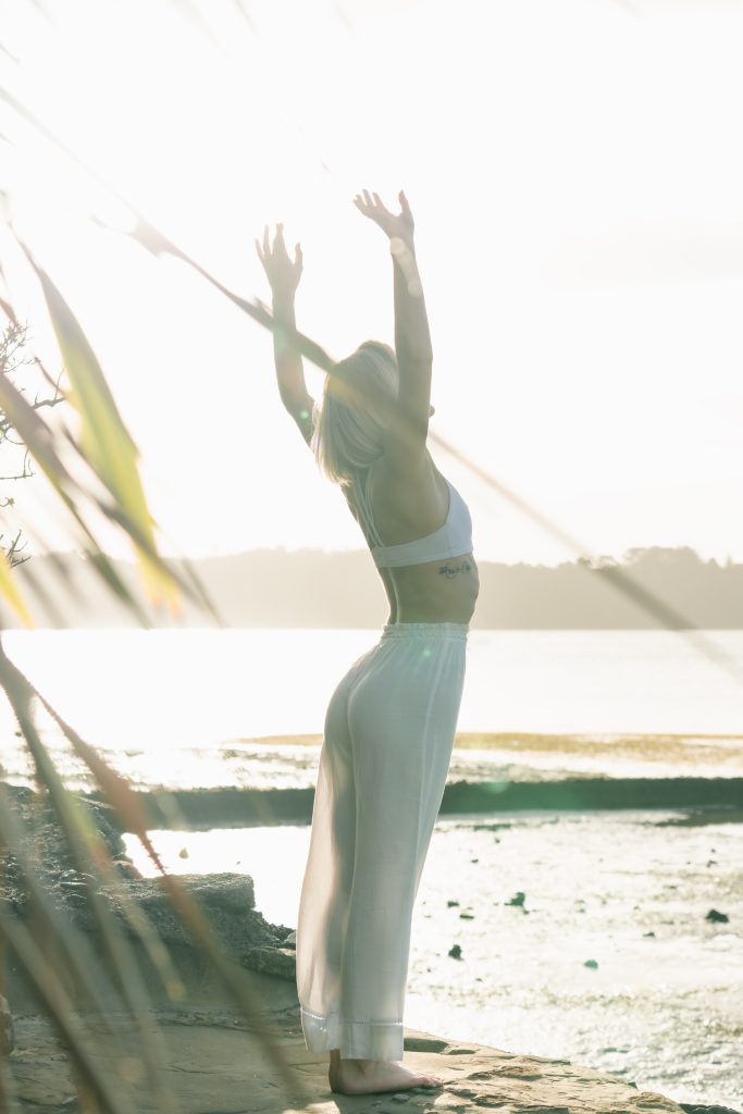 Wellness Journey - lady stretching infront of the water