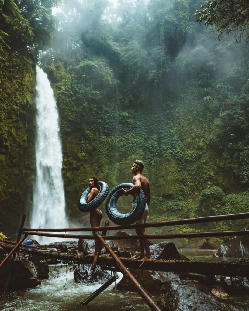 Couple head towards a waterfall with rubber rings