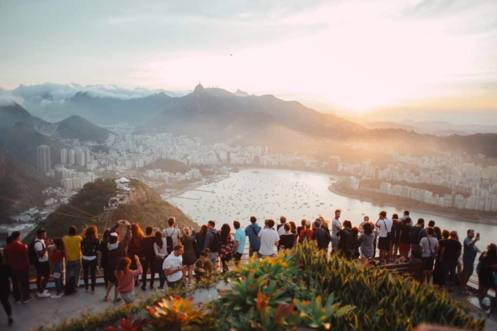 A large group of people stand over a beautiful view