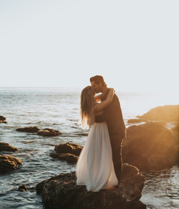 Couple kiss on rock in water